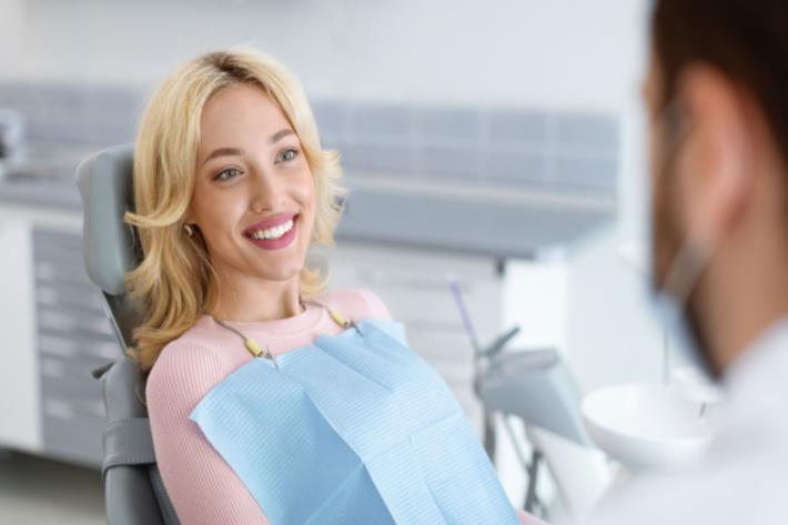 אישה מחייכת אחרי השתלת שיניים מוצלחת 