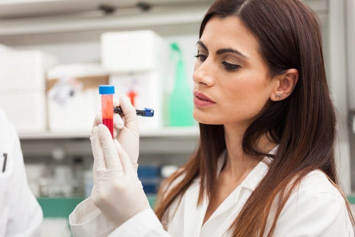 מדענית במעבדה כותבת על מבחנה של בדיקת אפיון תאים FACS