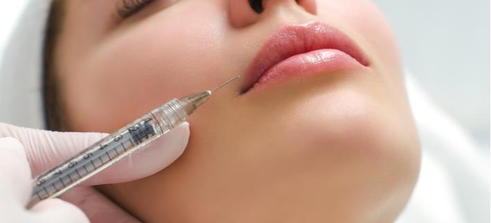 אישה עוברת טיפול לפיסול פנים באמצעות הזרקות של חומצה היאלורונית
