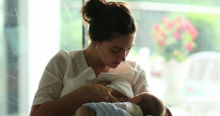 אישה מוטרת מניקה את התינוק, יתכן שסובלת מדיספוריה בהנקה
