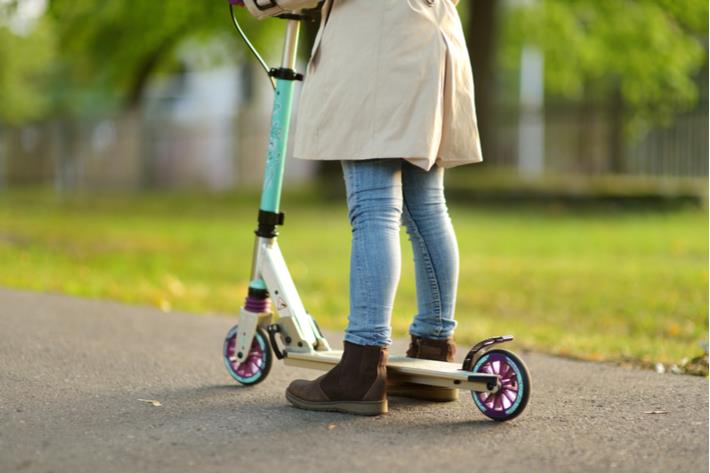 אישה נוסעת על קורקינט